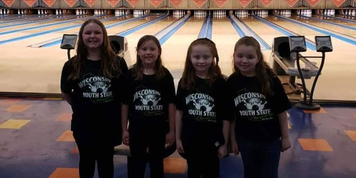 Chippewa Falls Bowl youth and junior league bowlers pose in front of the bowling lanes